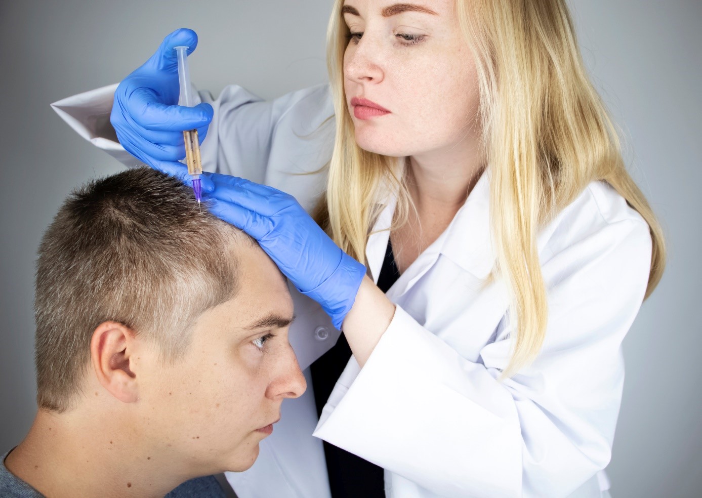 Traitement de la chute des cheveux, un médecin injecte un médicament dans la tête d'un monsieur, un patient