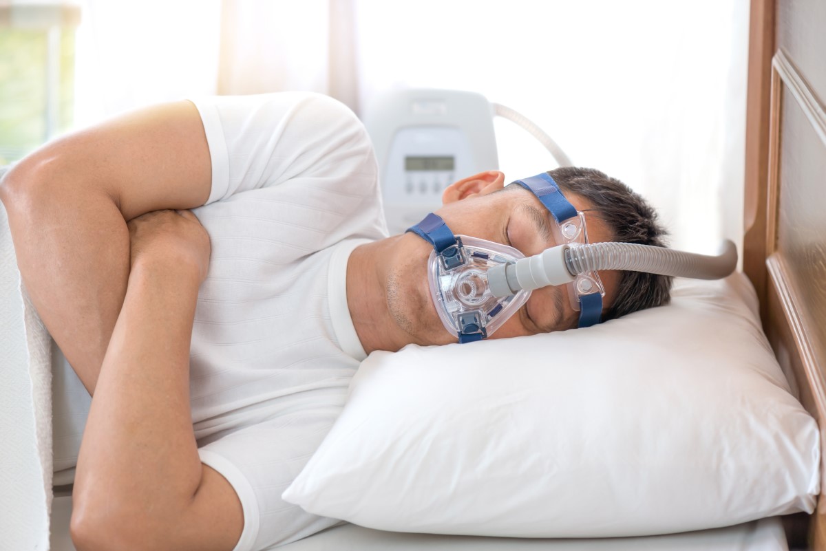 Masque CPAP sur le visage d'un homme souffrant d'apnée du sommeil