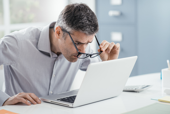 Le problème, c'est la lecture : l'homme derrière l'ordinateur ne voit pas bien sans lunettes.