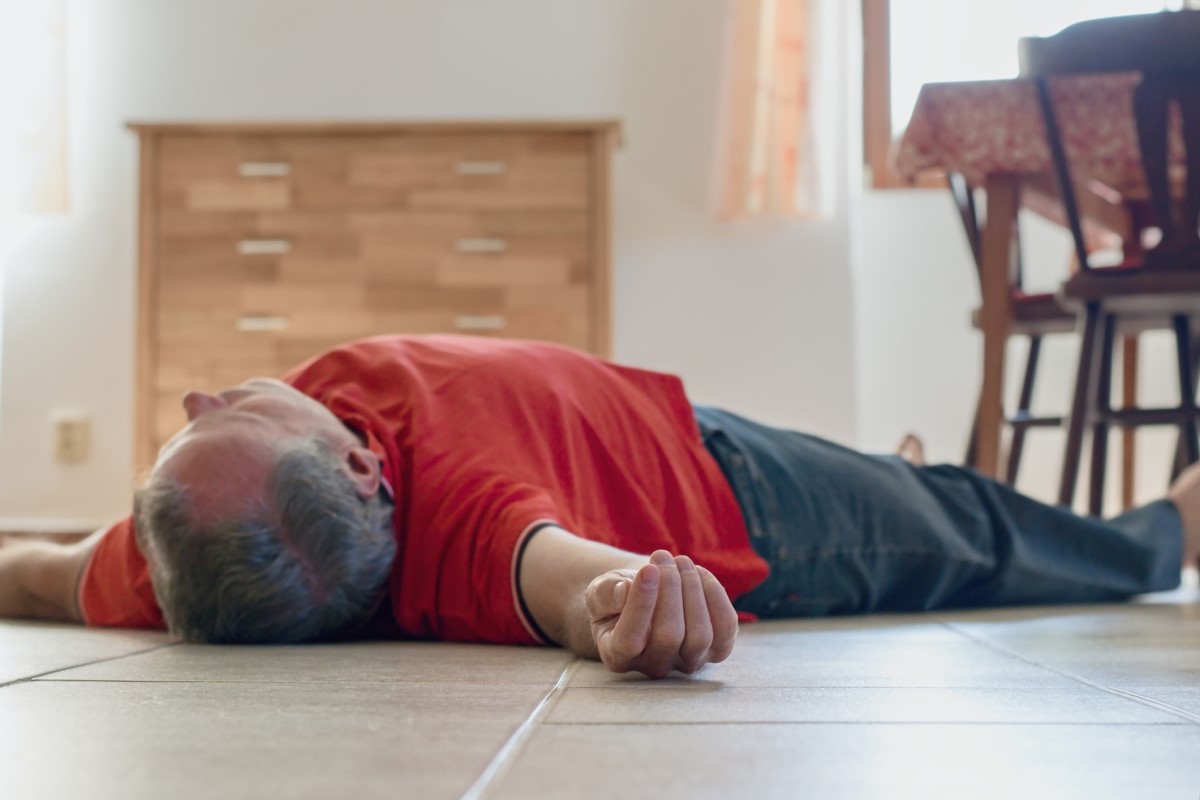 Un homme inconscient allongé sur le sol d'une maison