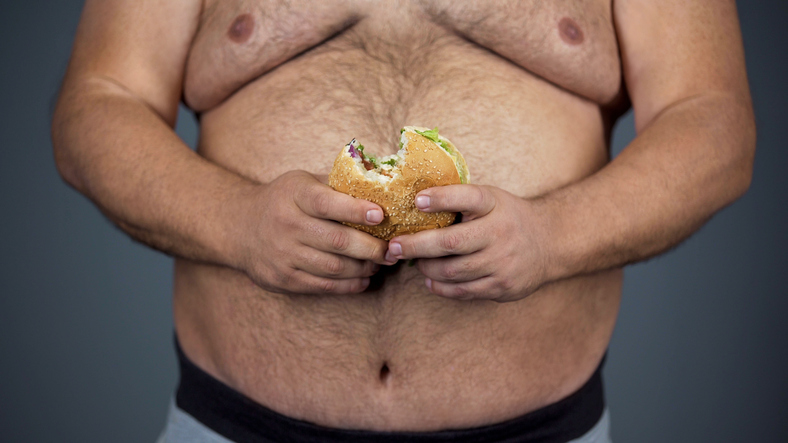 Un homme, un gros ventre et un hamburger