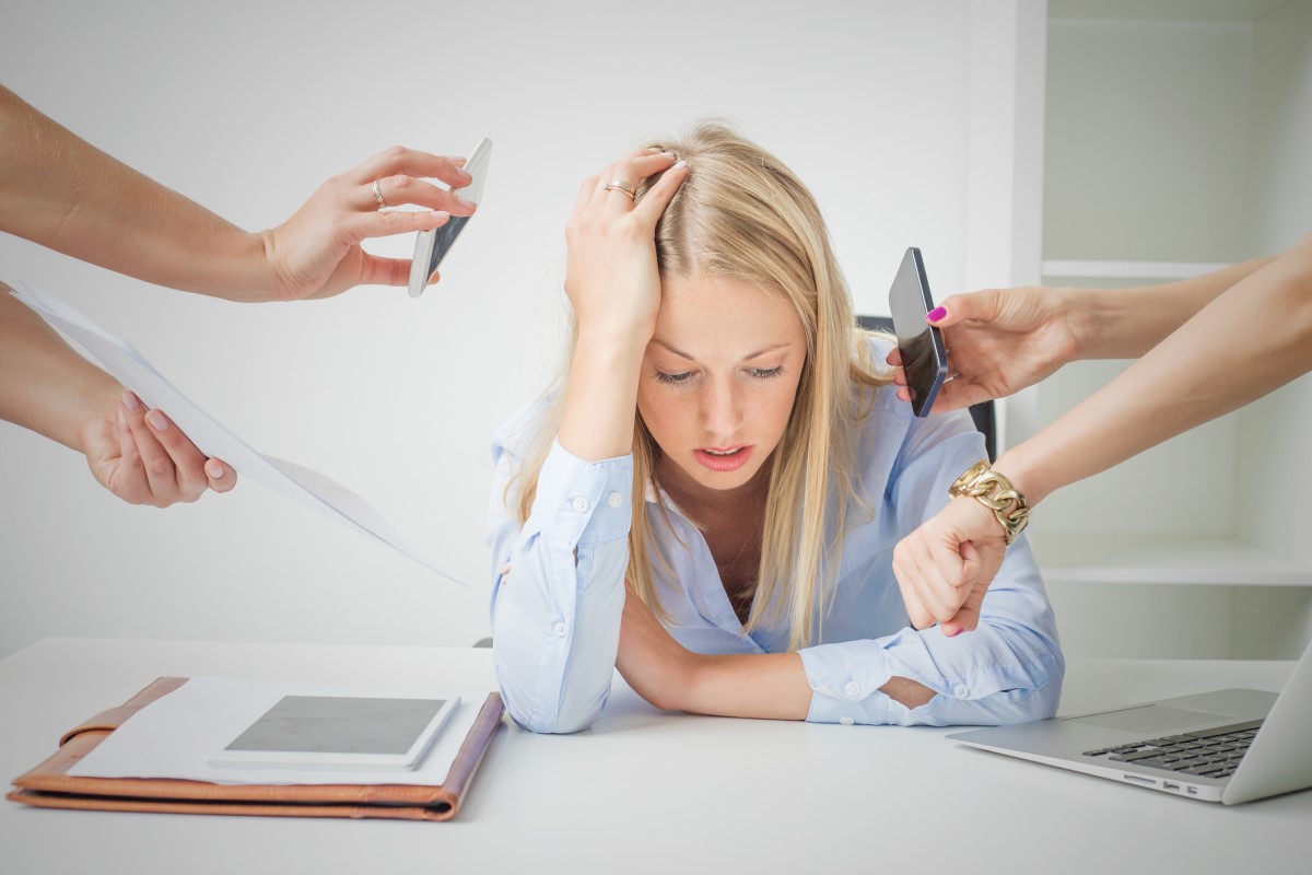 La femme n'est pas intéressée par le travail, elle est surmenée, épuisée, assise à son bureau et ne travaille pas.