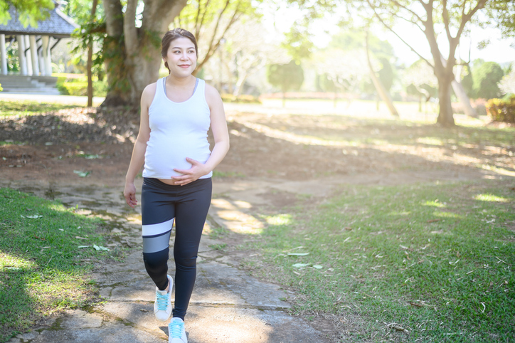 Femme enceinte marchant dans le parc.