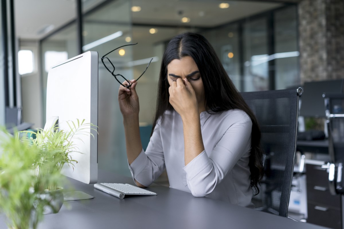 Maux de tête, fatigue, une femme assise à une table