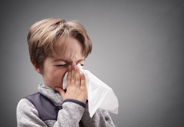 Le garçon se mouche dans un mouchoir hygiénique.