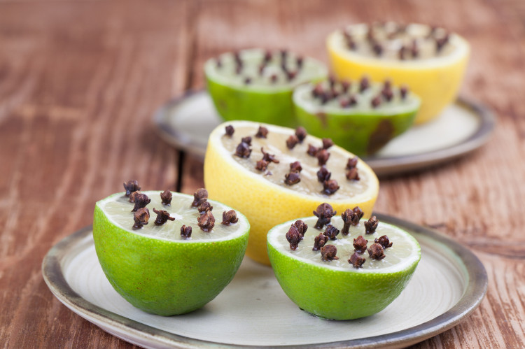 citrons et limes coupés en deux et un clou de girofle enfoncé dedans