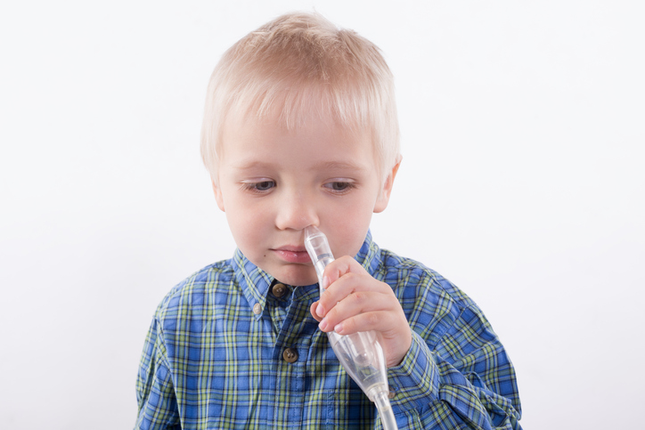 Le garçon porte un extracteur de mucus à son nez.