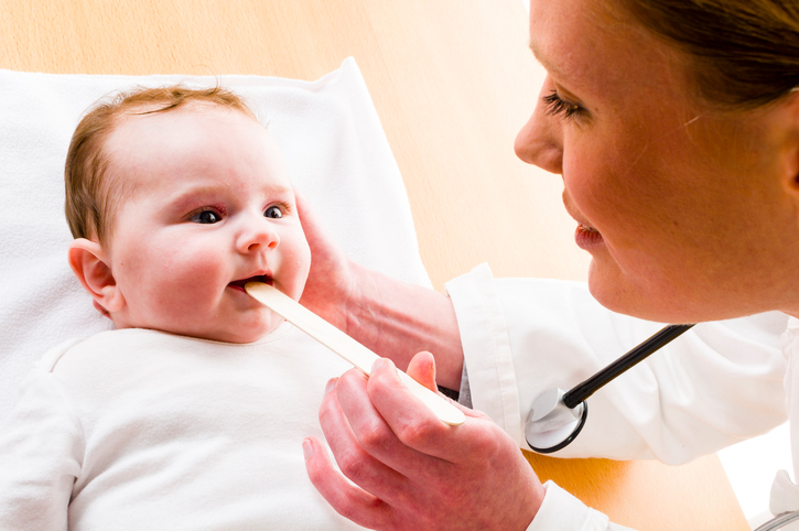 bébé avec la bouche ouverte, la mère regardant dans sa gorge avec un maillet