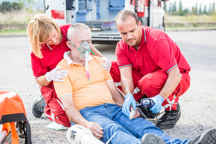 des ambulanciers à côté d'un patient effondré