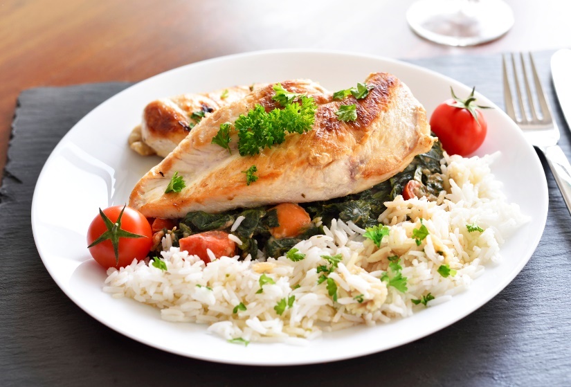 Exemple de déjeuner : blanc de poulet grillé avec du riz, des herbes et des légumes frais.