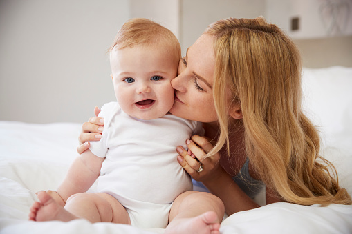 mère embrassant son enfant heureux