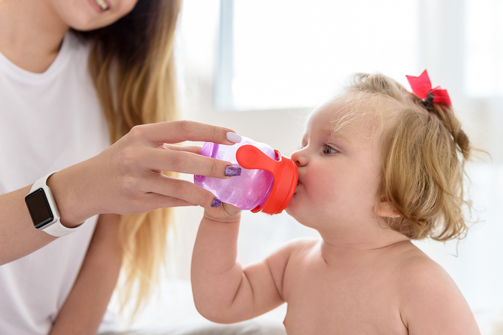 Une mère donne de l'eau propre à boire à une petite fille