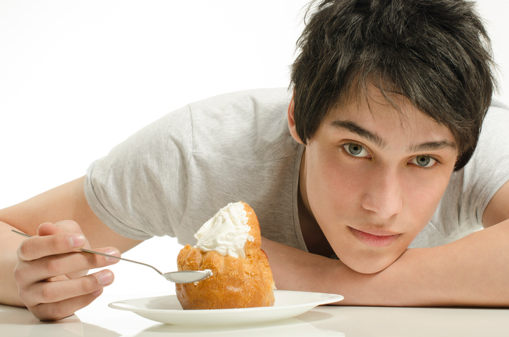 un homme assis à une table avec un dessert sucré devant lui