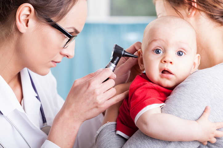 un médecin examine l'oreille d'un enfant à l'aide d'une machine