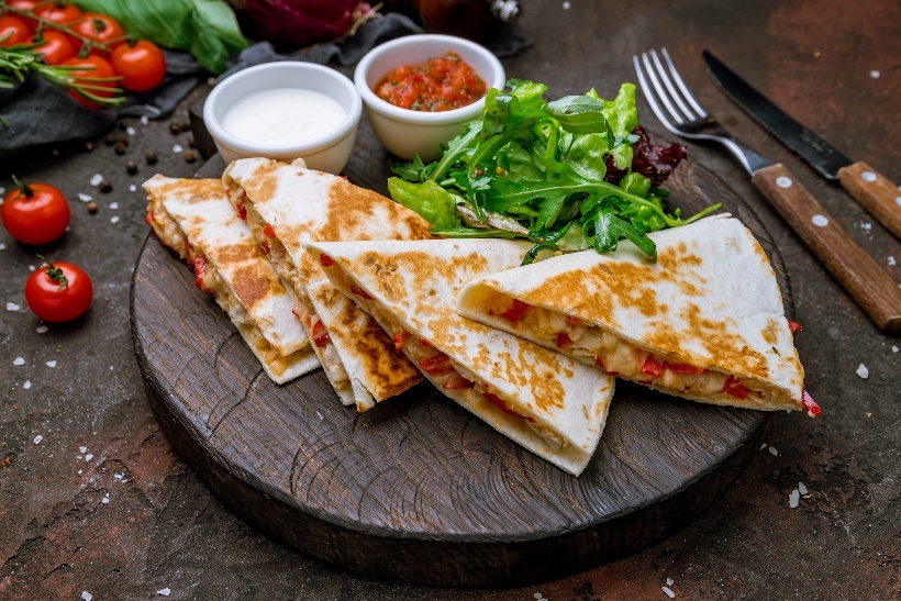 Exemple de déjeuner : quesadilla cuite au four avec de la viande/des haricots et des légumes. Plat d'accompagnement avec de la sauce tomate et des légumes frais.