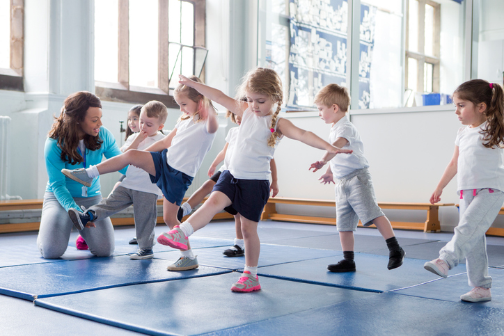 Jeunes enfants dans le gymnase, s'entraînant avec le professeur.