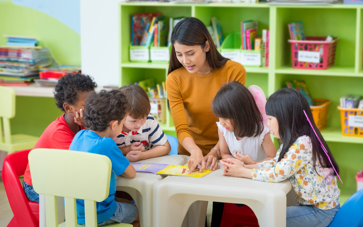 Une institutrice de maternelle lit un livre aux enfants