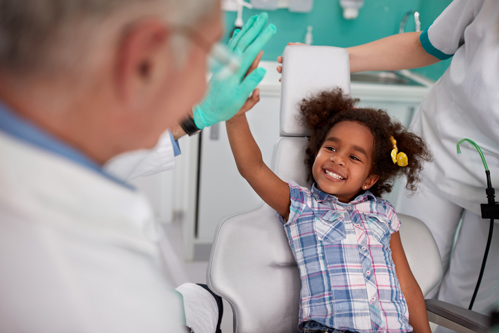 la fille qui rit sur le fauteuil du dentiste avec le dentiste.