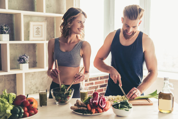 Un homme et une femme préparent un repas sain dans la cuisine.