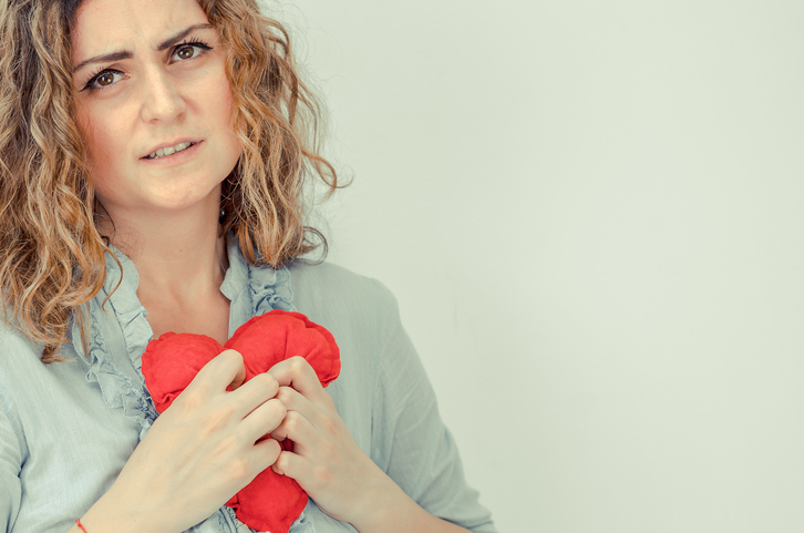 femme tenant un coeur en peluche rouge