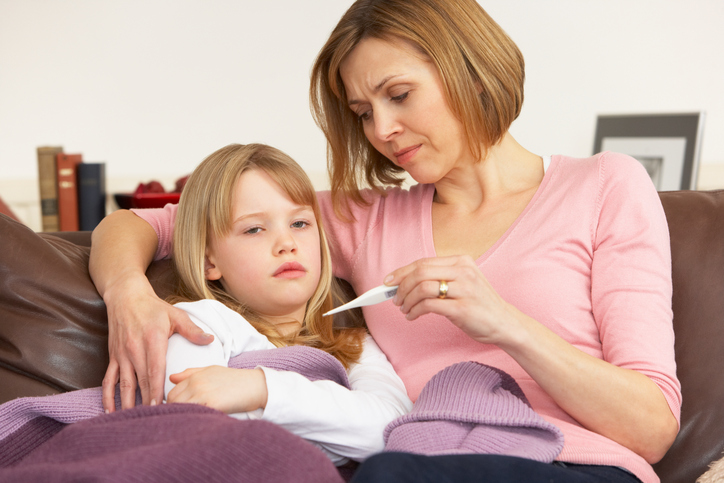 Une mère inquiète prend la température de sa fille