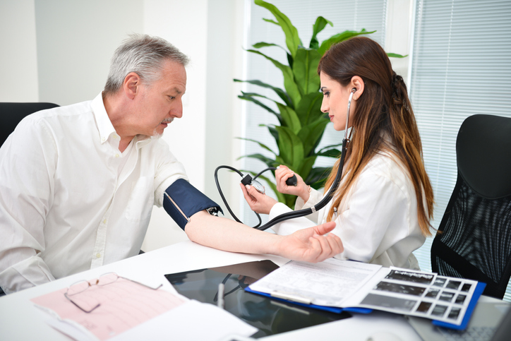 Un médecin mesure la tension artérielle d'un homme