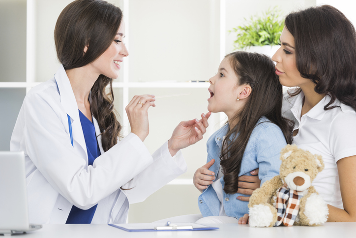 Médecin examinant le mal de gorge d'une jeune fille