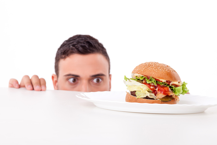 L'homme a de l'appétit, il y a un hamburger dans son assiette