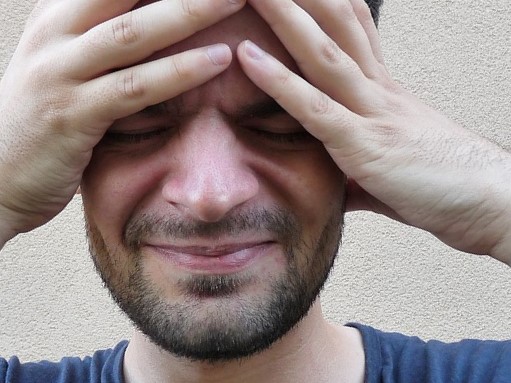 L'homme se tient la tête, il a la migraine