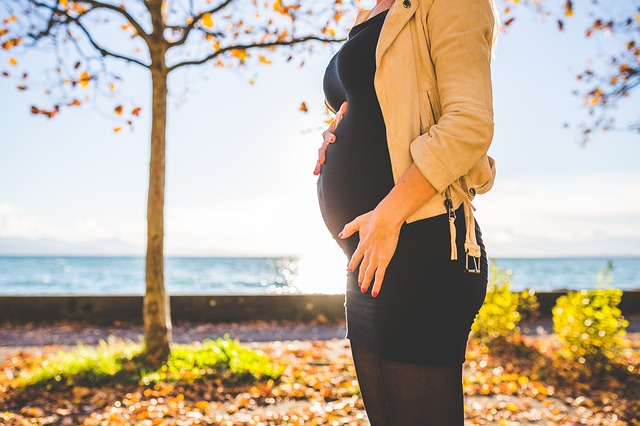 femme enceinte devant un arbre en automne