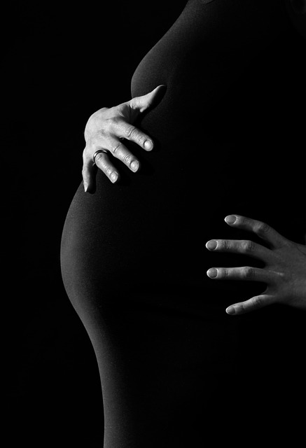 Femme enceinte, découpe, poitrine, ventre, bras, robe noire