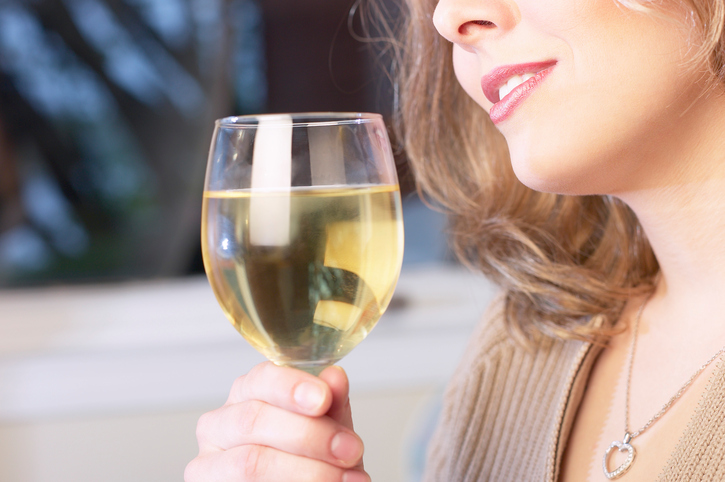 Femme buvant de l'alcool, vin dans un verre, découpe du visage d'une femme - nez et bouche - tenant un verre. L'alcoolisme à long terme comme cause de troubles de la déglutition.