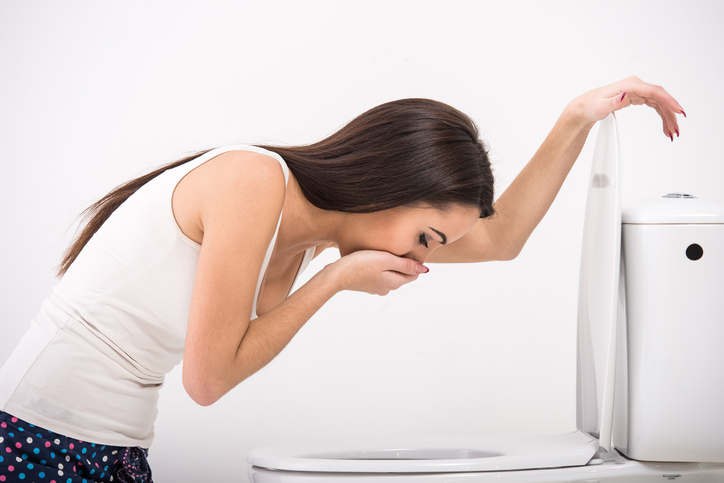 Une femme a des nausées dans les toilettes, elle est sur le point de vomir.