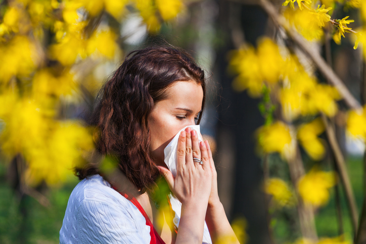 Une femme se mouche en cas de rhume des foins, une allergie au pollen.